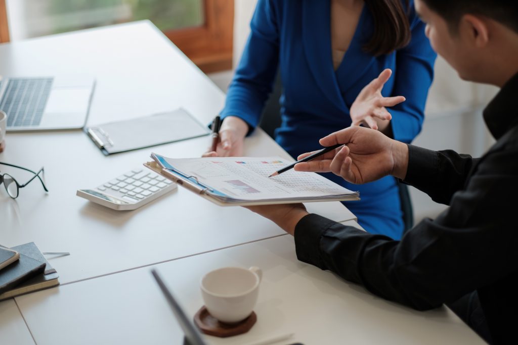 Two colleagues discussing data with document data on desk table. Close up business people meeting to